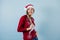 Latin man in christmas concept listening to music with headphones and mobile phone with santa hat on a yellow background in Mexico