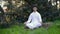 Latin man meditating in a green park