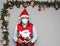 Latin man with protection mask and santa claus doll in christmas decoration, new normal covid-19