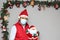 Latin man with protection mask and santa claus doll in christmas decoration, new normal covid-19