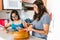 Latin mom slicing fruit with her teenage daughter with down syndrome in the kitchen, in disability concept in Latin America