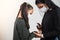 Latin mother applies disinfectant to her daughter to prevent infection, the two girls wear a protective mask. Infection