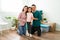 Latin parents smiling with their daughter during moving day