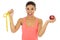 Latin sport woman in fitness clothes holding apple fruit and measure tape smiling happy