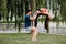 Latin woman and Caucasian shadow do yoga exercises in a park in Madrid. Balance and concentration in couple