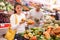 Latin woman choosing sweet pepper and man near choosing melon