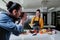 Latin woman Food Blogger shooting food on table while a photographer man is taking pictures with camera of mexican food at kitchen