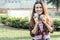 Latin woman with green eyes in a park smiling with headphones in her hands.