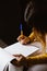 Latin woman hands writing and signing a document or a questionnaire in South America