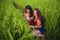 Latin woman and her attractive red hair girlfriend both girls enjoying Summer holidays together sitting on rice field smiling