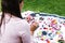 Latin woman holding a rose and chakra crystals, candles and rose petals on the grass in Latin America