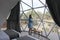 Latin woman inside a geodesic glamping tent with beds and transparent roof to see the sky and stars