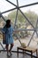 Latin woman inside a geodesic glamping tent with beds and transparent roof to see the sky and stars