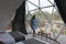 Latin woman inside a geodesic glamping tent with beds and transparent roof to see the sky and stars