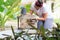 Latin woman painting chair at home. A female is upcycling a wooden seat, She is kneeling on the floor