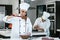 Latin woman pastry chef wearing uniform holding a bowl preparing delicious sweets chocolates at kitchen in Mexico Latin America