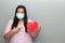 Latin woman with protection mask clinical use and red heart, valentine in contingency covid-19