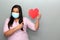 Latin woman with protection mask clinical use and red heart, valentine in contingency covid-19