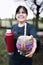 Latin woman serving mate with a red thermo, in a colorful ethnic mate. Vertical