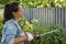 Latin woman working on the yard cutting bush with hedge shear