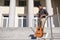 Latin young man chatting on his smartphone with a guitar standing on stairs