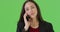 A Latina business professional take a call on her mobile phone on green screen