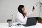 Latina doctor woman works in her office very busy uses her cell phone to answer messages, calls and video calls from patients