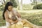 Latina mother breastfeeding her daughter sitting on a blanket in a park