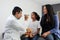 Latina mother cares for and accompanies her curly little daughter at the dark-haired pediatrician specialist doctor`s office to pr