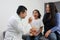 Latina mother cares for and accompanies her curly little daughter at the dark-haired pediatrician specialist doctor`s office to pr