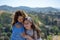 Latina Mother and Daughter Smiling and laughing on a hill in front of yellow flowers