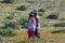 Latina Mother and Daughter walking in desert California Poppy field on path