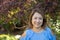 Latina Mother Smiling in Back Yard in front of red leaved bush