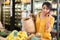 Latina talking on phone while looking for vegetables and fruits at grocery store