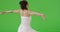 A Latina woman spins in her sundress on green screen