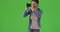 A Latina woman takes pictures on green screen