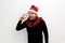 Latino adult man with Christmas hat shows Christmas decorations and decorations because he is ready to celebrate the holidays and