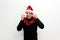 Latino adult man with Christmas hat shows Christmas decorations and decorations because he is ready to celebrate the holidays and