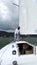 Latino adult man drives a sailboat on the lake with sails unfurled as a physical activity, sport and hobby to relax for the weeken