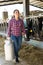 Latino american female farmer holding milk can