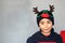 Latino boy 7 years old with Christmas hat with reindeer ears and sweater. Christmas decoration