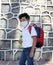 Latino boy with uniform shirt, mask, backpack, notebook and bottle of water back to school in the new normal due to the Coronaviru