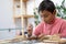 Latino boy using tool to assemble wooden toy