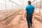 Latino farmer seen from behind in a controlled environment greenhouse to improve the genetics of vegetables