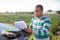 Latino farmer signing papers near car