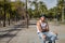 Latino and Hispanic boy, young, rebellious, with headscarf, arms crossed and looking defiantly at camera, sitting on a bench.