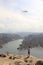 Latino man flying multicolored kite at El Vigilante viewpoint and in the background the Zimapan dam in Hidalgo Mexico