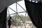 Latino man inside a geodesic glamping tent with beds and transparent roof to see the sky and stars