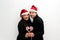 Latino man woman couple with Christmas hat and garland as scarf show their love and excitement for the arrival of December and cel