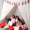 Latino man and woman couple in love and happy share their love with kisses and hugs under a teepee and the sign that says `love` c